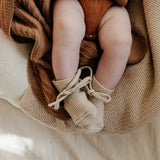Babybeine-in-Strickschuechen-und-Wolldecken